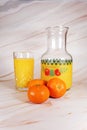 Oranges and orange juice in carafe and glass.