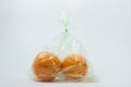 Oranges in a plastic bag on a white background. Royalty Free Stock Photo