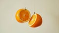 oranges sliced in half hanging against a soft background. creative food concept Royalty Free Stock Photo
