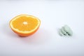 Oranges and Vitamin tablets in white background