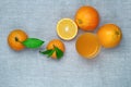 Oranges, tangerines and orange juice in a glass, on a linen tablecloth. Top view.