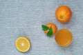 Oranges, tangerines and orange juice in a glass, on a linen tablecloth. Top view.