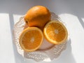 Oranges in a white plate on white background