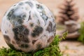 Orbicular ocean jasper sphere with crystallized vugs from Madagascar on moss, bryophyta and cork Royalty Free Stock Photo