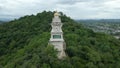 Orbital Drone Shot Around a Clock Tower Nestled Amongst Trees in Ratchaburi, Thailand from an Aerial Drone