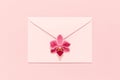 Orchid flower on pink envelope on pink background, congratulation card.