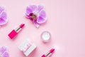 Orchid flowers and decorative cosmetics on pink background. Make up female accessories, stylish flat lay, top view, copy Royalty Free Stock Photo