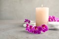 Orchid flowers, spa stones and  on grey table. Space for text Royalty Free Stock Photo