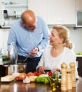 Ordatary mature couple cooking Spaniard tomatoes