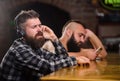Order drinks at bar counter. Men with headphones and smartphone relaxing at bar. Avoid communication. Escape reality Royalty Free Stock Photo