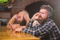 Order drinks at bar counter. Men with headphones and smartphone relaxing at bar. Avoid communication. Escape reality Royalty Free Stock Photo