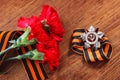 Order of the patriotic war 1st class and two red carnations. Victory Day. 9 May. selective focus image Royalty Free Stock Photo