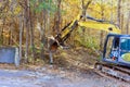 In order to prepare land for construction builder uproots trees in a forest using tractor