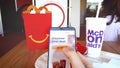 Ordering Mc Donalds food online in a McDonald fastfood restaurant with smartphone