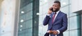 Ordering a Taxi. African businessman arriving to airport and talking on phone Royalty Free Stock Photo