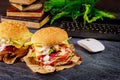 Ordering two big sandwiches to home. Desk with keyboard, mouse and books Royalty Free Stock Photo