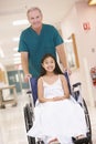 An Orderly Pushing A Little Girl In A Wheelchair Royalty Free Stock Photo