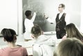 Aframerican student answers near blackboard at math lesson