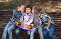 Ordinary children whispering in park on bench in autumn