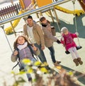 Ordinary family spending time at children swings Royalty Free Stock Photo