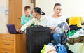 Ordinary family of three with luggage choosing the tickets on th