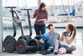 Ordinary friends posing near segways on shore