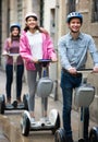 Ordinary friends posing on segways on city street