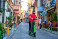 Ordinary life in the old district of Istanbul. two guys are riding along a narrow street on one electric scooter