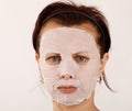 Housewife woman with a sheet mask on her face