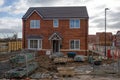 ordinary new semi-detached house for sale and two recycling skips in front of it Royalty Free Stock Photo