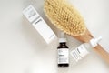 The Ordinary skincare brand by Deciem. Bottles with oil and treatments. Massage anti cellulite body brush. Spa concept