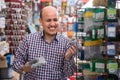 Ordinary smiling senior man choosing nails Royalty Free Stock Photo