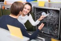 Young customers choosing new dish washing machine in supermarket Royalty Free Stock Photo