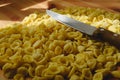 Orecchiette, Italian wheat semolina pasta, on a table and a knife Royalty Free Stock Photo