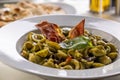 Orecchiette small Italian pasta with pesto and crunchy strips of bacon