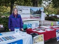 Oregon climate activist poses beside no-LNG information table at