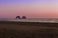 Oregon coast beach with a magnificent sunset with rocks in the distance in the ocean