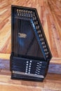 Oregon, USA - May 18, 2023: A black vintage 12-chord autoharp on a wood floor