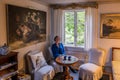 Oregrund, Uppland - Sweden -Woman posing in the traditional 19th century wooden interior design of a bed and breakfast living room