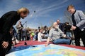 Orel, Russia - April 29, 2017: Russian traveler festival. Orthodox clergyman, boy and senior traveler looking at world map