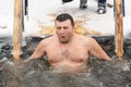 Orel, Russia - January 19, 2016: Russian epiphany feast. Man descending into cold water of ice-hole