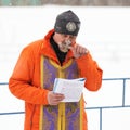 Orel, Russia - January 19, 2016: Russian epiphany feast. Orthodox priest kissing cross for blessing water in ice-hole Royalty Free Stock Photo