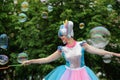 Orel, Russia, May 26, 2019: Twin Festival. Smiling woman in bright unicorn costume dancing and making big soap bubbles