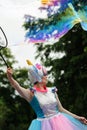 Orel, Russia, May 26, 2019: Twin Festival. Woman in bright unicorn costume making big soap-bubbles