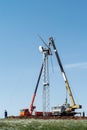 Construction of a wind power plant. Installers using a truck crane and aerial platform install a wind turbine rotor Royalty Free Stock Photo