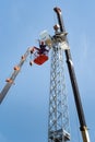 Workers on an aerial platform with the help of a crane carry out the installation of a wind turbine