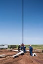 Workers-slingers on a construction site prepare a wind turbine rotor for lifting with a crane Royalty Free Stock Photo