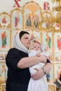 Orenburg, Russian Federation-2 Aprel 2019. Woman holding a baby during the baptism ritual