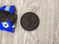 Oreos with open wrap on wood background. It is chocolate sandwich cookies with vanilla flavored cream.