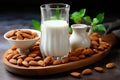 Organic almond milk in a glass, nuts and flowers